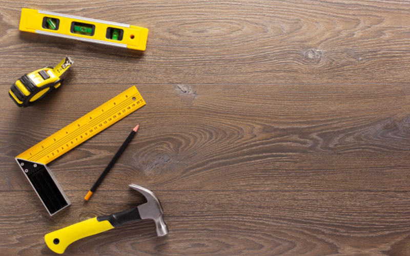 Dark wood grain LVT flooring and installation tools.