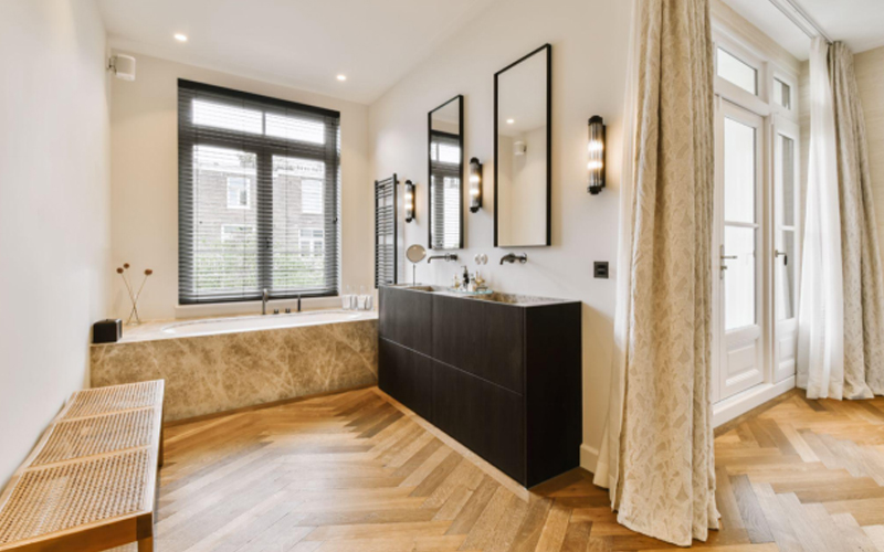 A modern bathroom with LVT or LVT flooring and a bathtub in the center of the room
