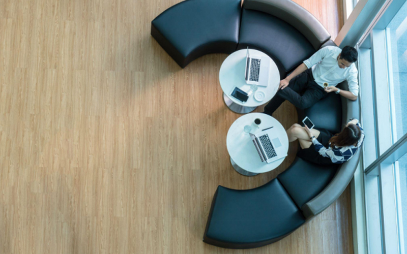 Business professionals discussing in an office with luxury LVT flooring