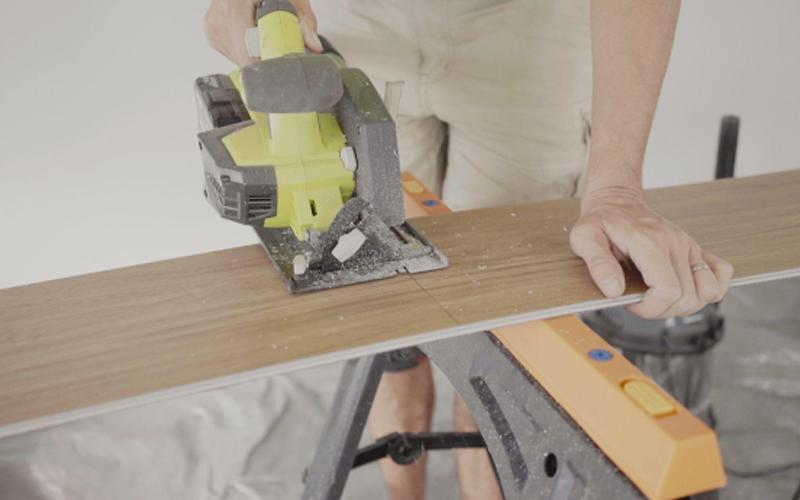 A man is cutting and installing LVT flooring.