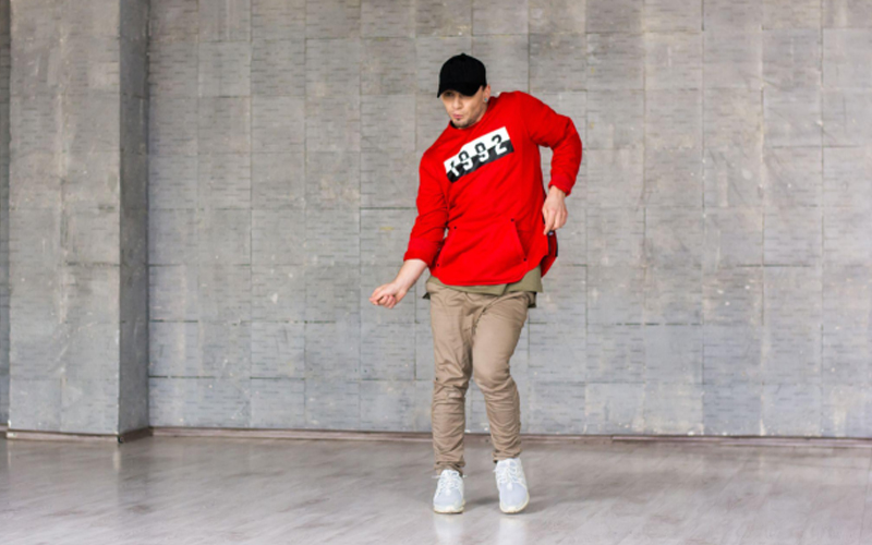 Stylish guy dancing break dance on LVT flooring.