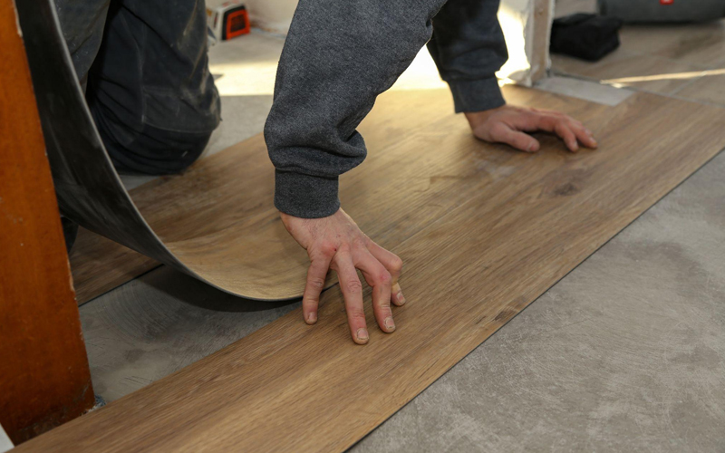 Worker installing resilient flooring
