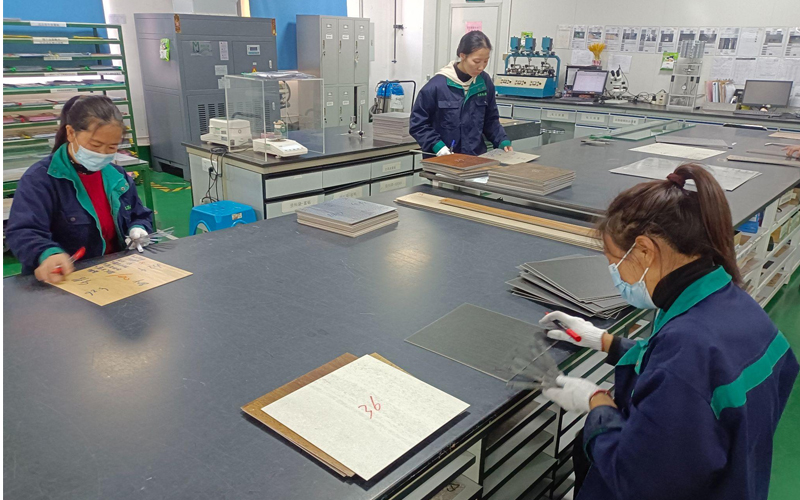 Three professionals examining flooring quality indicators in a laboratory.
