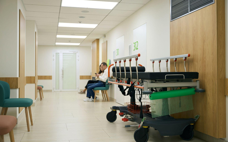 People in casual clothes are sitting in a hospital corridor 