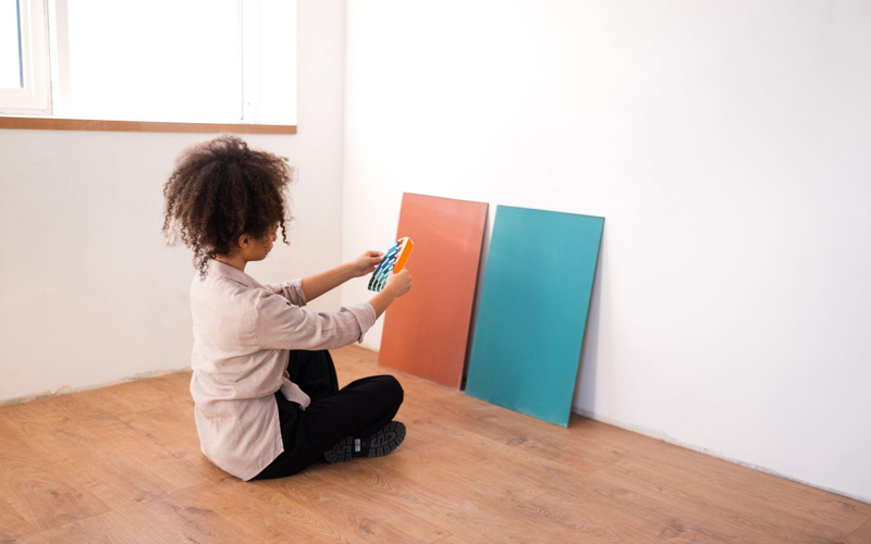 A woman in casual clothes holds color palettes