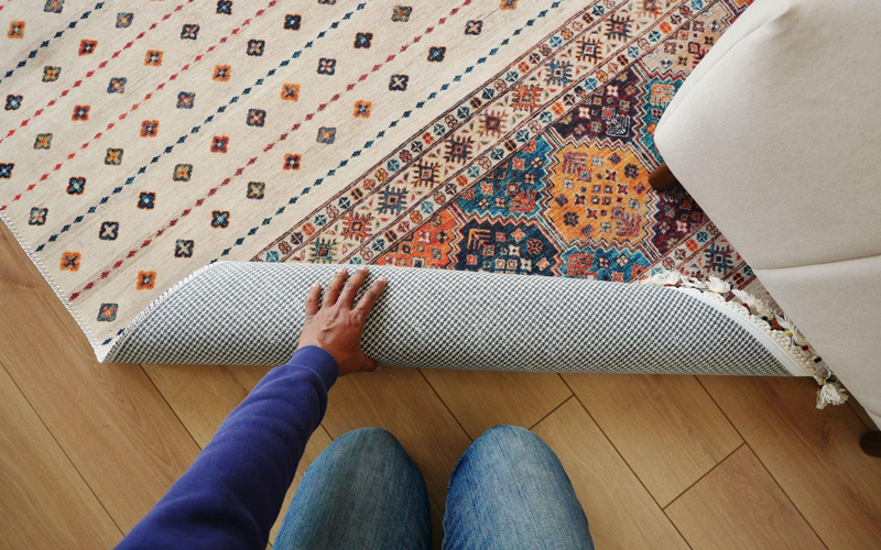 Top view of man rolling up a new rug on LVT flooring